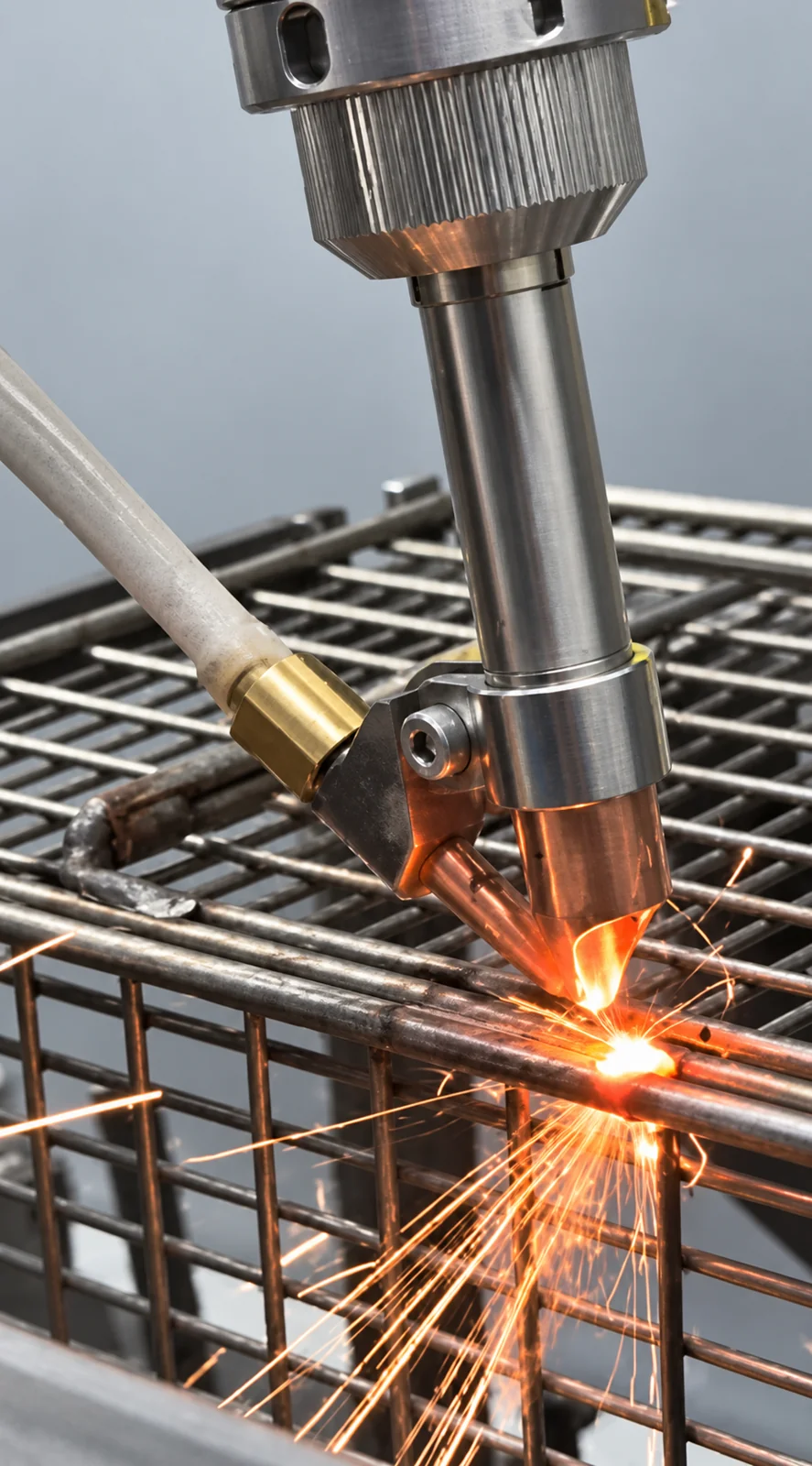 Close-up of wire-feed laser welding on a stainless industrial fryer basket